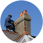A professional specializing in residential roofing services is repairing a chimney on a rooftop adorned with slate tiles and decorative orange accents, all under a clear blue sky.